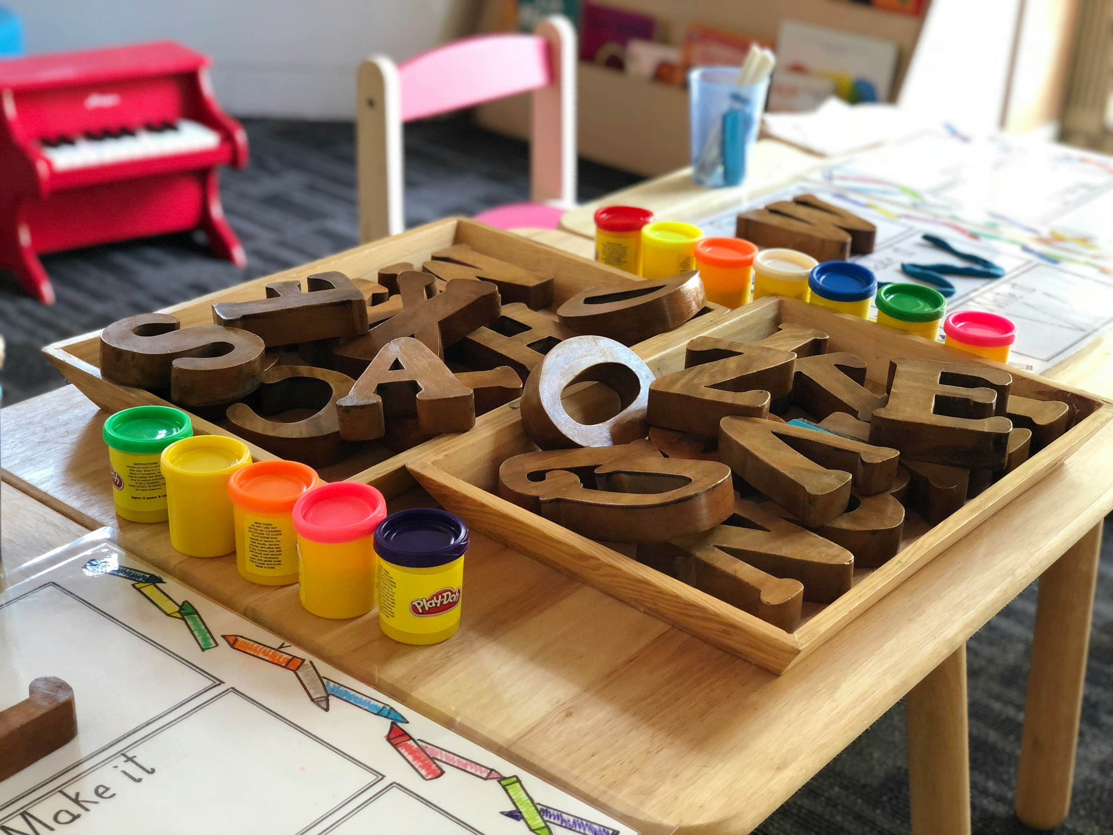 Wooden letter blocks and Play-Doh for early language learning